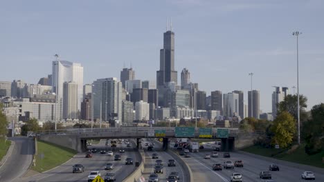 establish cars driving on highway in front of chicago skyline on a sunny day