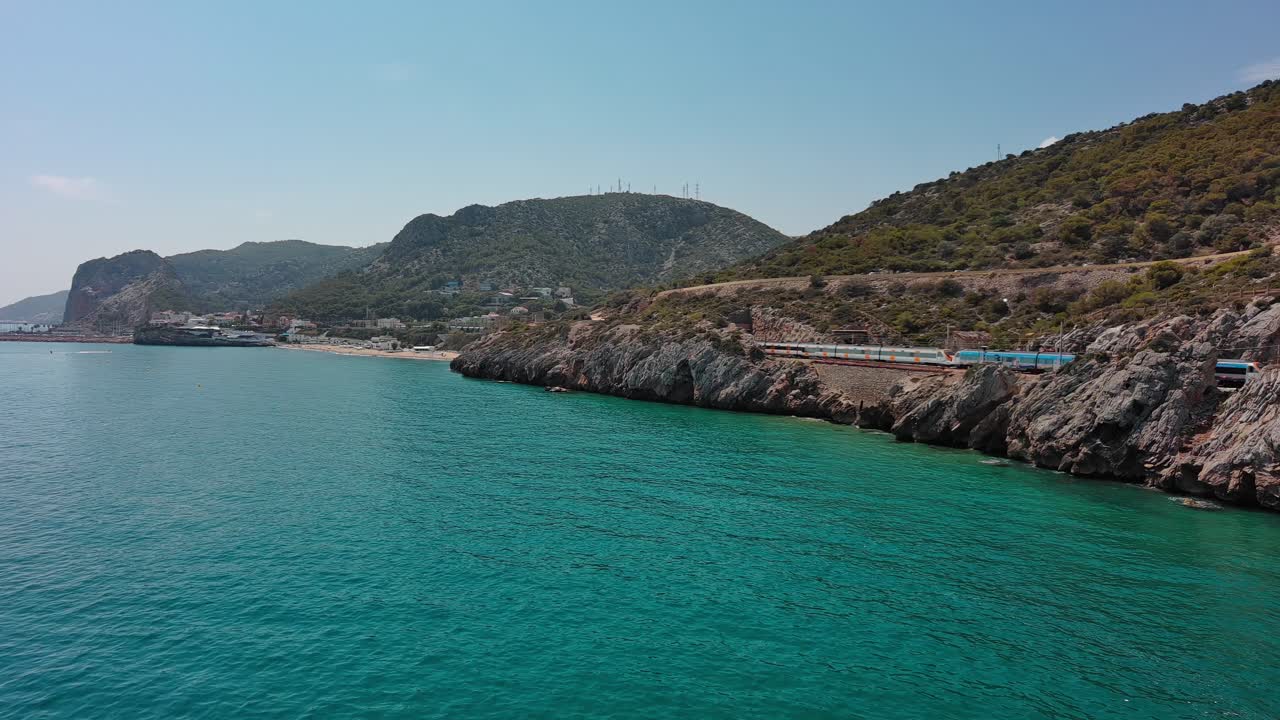 Train runs on shore of Garraf coast near Ginesta port in summer