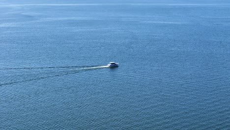 private boat speeding through calm lake near gizycko, aerial view