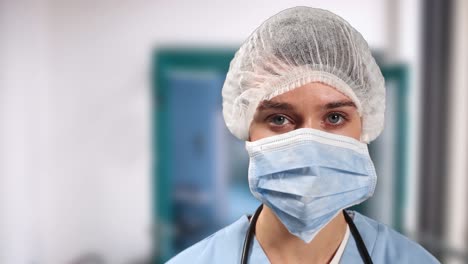 Porträt-Einer-Kaukasischen-Chirurgin-Mit-Gesichtsmaske-Und-OP-Haube-Im-Krankenhaus