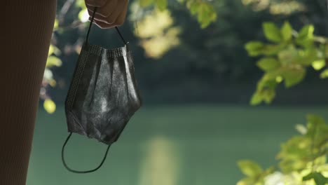 girl holding mask in lake side in forest close up