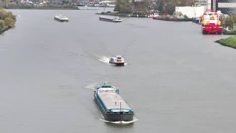 numerous cargo vessels sailing on the river noord, ridderkerk, netherlands