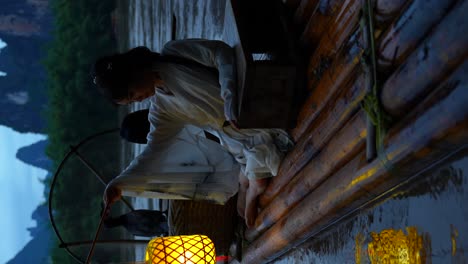 Girl-in-Hanfu-admires-a-lantern-reflection-from-a-bamboo-raft-on-the-Li-River-in-Xingping,-China