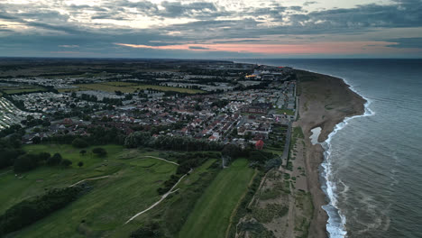 Skegness-seaside-beauty-captured-in-aerial-drone-video-at-sunset:-holiday-park,-beach,-caravans,-and-sea-showcased