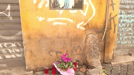 mural located in rome done by harry greb and dedicated to football legend diego maradona. the artist has portrayed maradona as the footballer's hero che guevara. tilt down revealing flowers.
