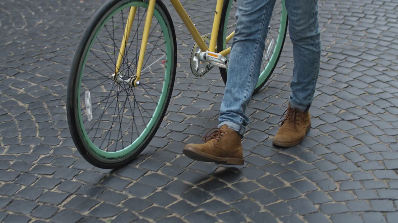 A person with a bicycle on a cobblestone street