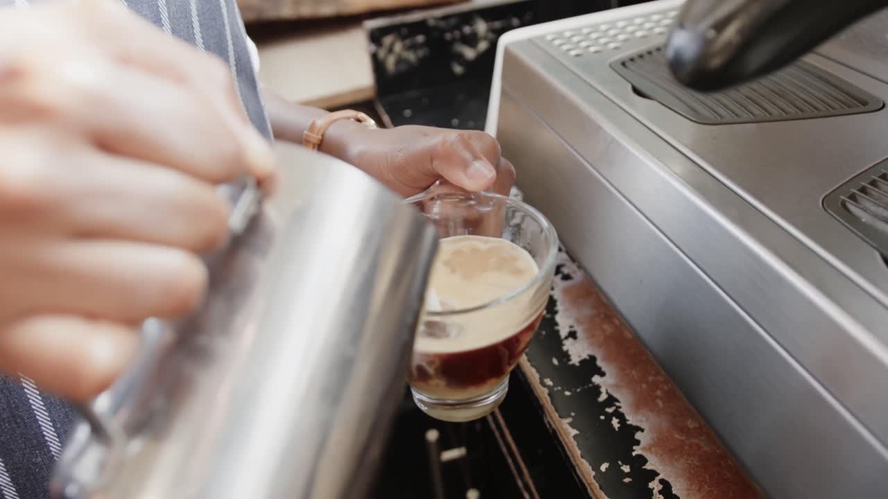 primer plano de una barista afroamericana preparando café con leche en una cafetería, cámara lenta
