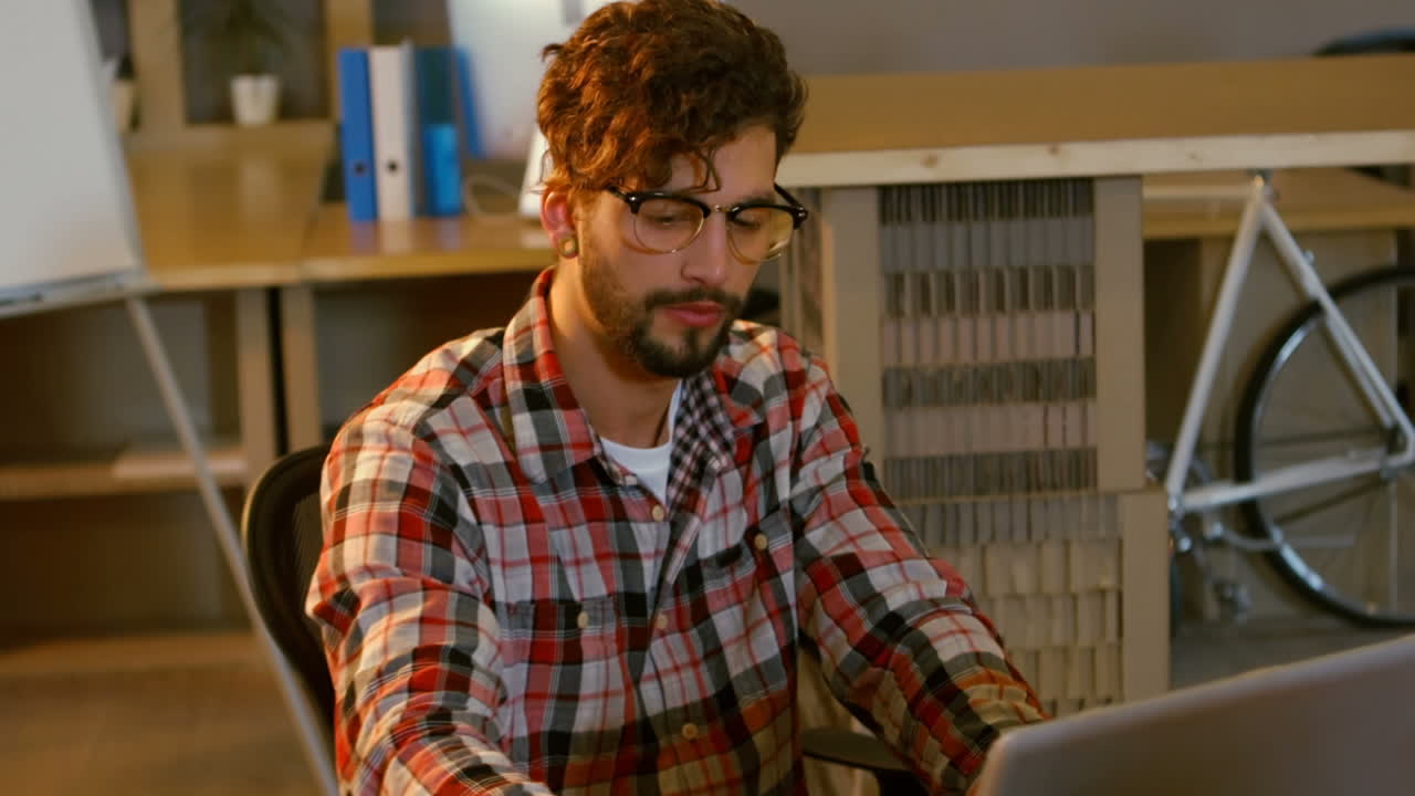 diseñador gráfico bebiendo café mientras trabaja en una computadora portátil