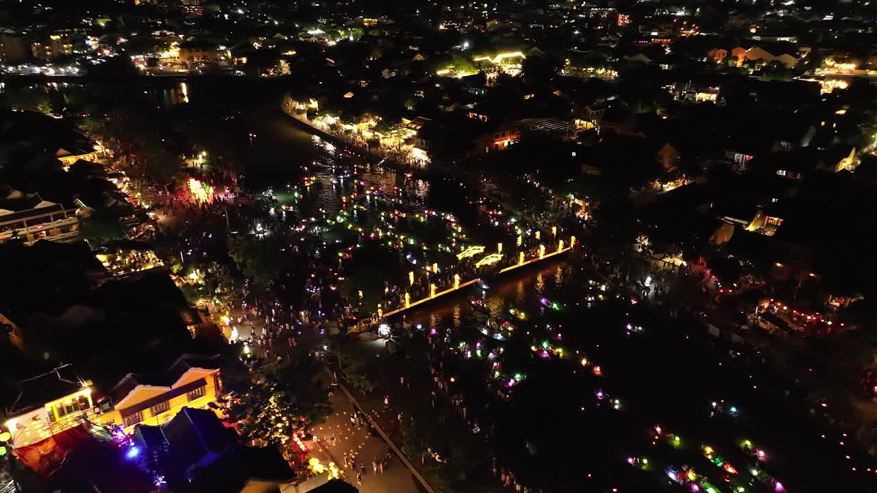 Lively night celebration in Hoi An with colorful lights on boats and crowds gathering