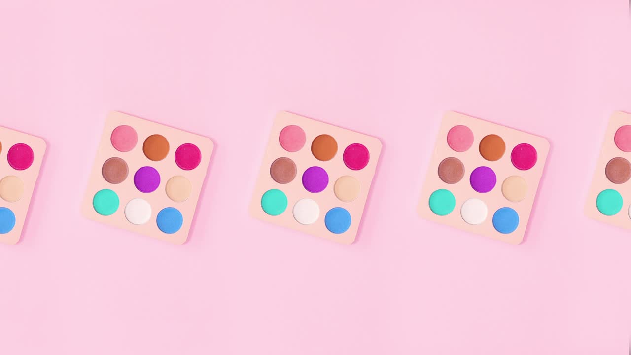 다채로운 눈 그림자 패이 밝은 분홍색 배경에서 회전합니다. 움직임을 멈추십시오.