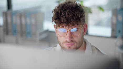 man with curly hair working on a computer