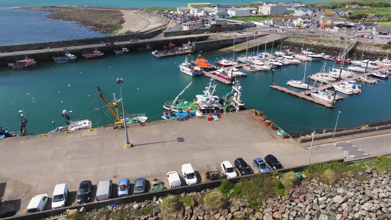 4K cinematic drone footage capturing Kilmore Quay, on a bright day, showcasing the picturesque harbour, and colourful fishing boats Co.Wexford - Ireland_001