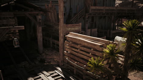 rustic setting featuring an old wooden structure with pallets and plants