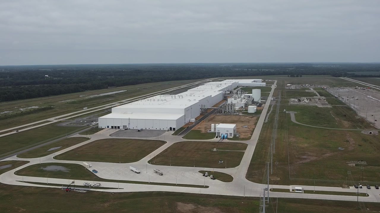 Drone aereo che avanza verso l'ampio complesso industriale BlueOval Battery Park e l'impianto di produzione di batterie per veicoli elettrici a Marshall, Michigan