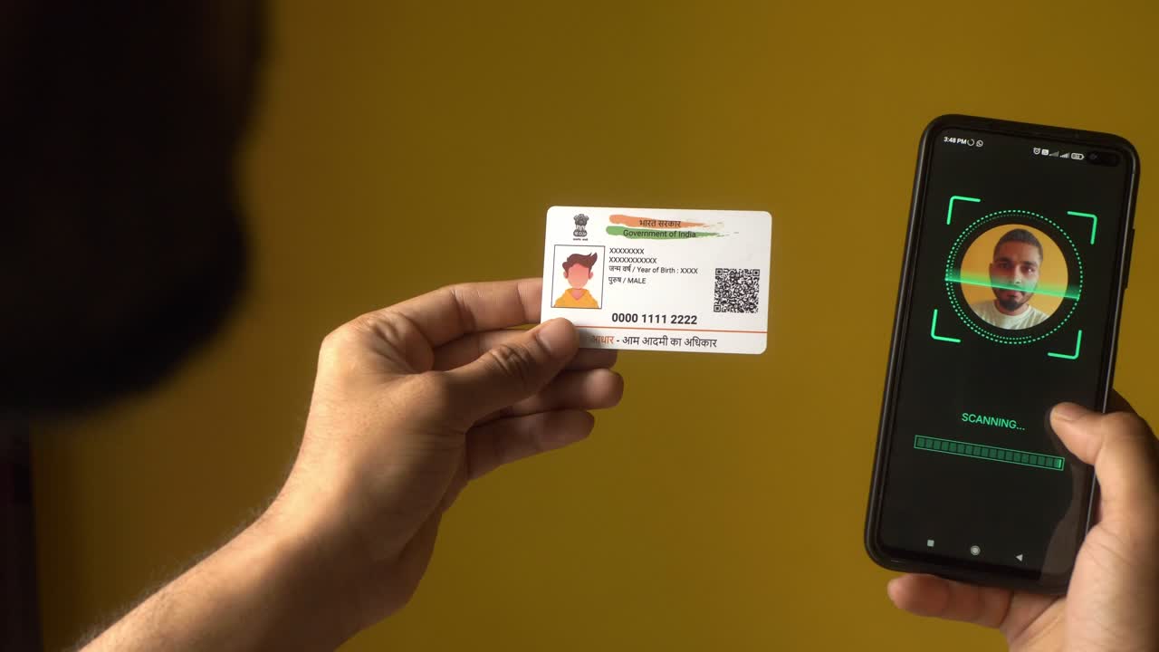 Indian nationality man scanning his face on a mobile phone for eKYC digital identity verification using Aadhaar card