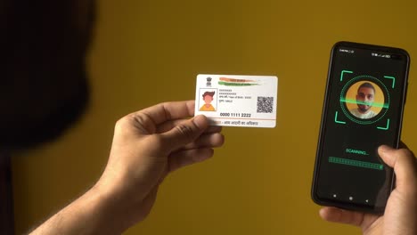 indian nationality man scanning his face on a mobile phone for ekyc digital identity verification using aadhaar card