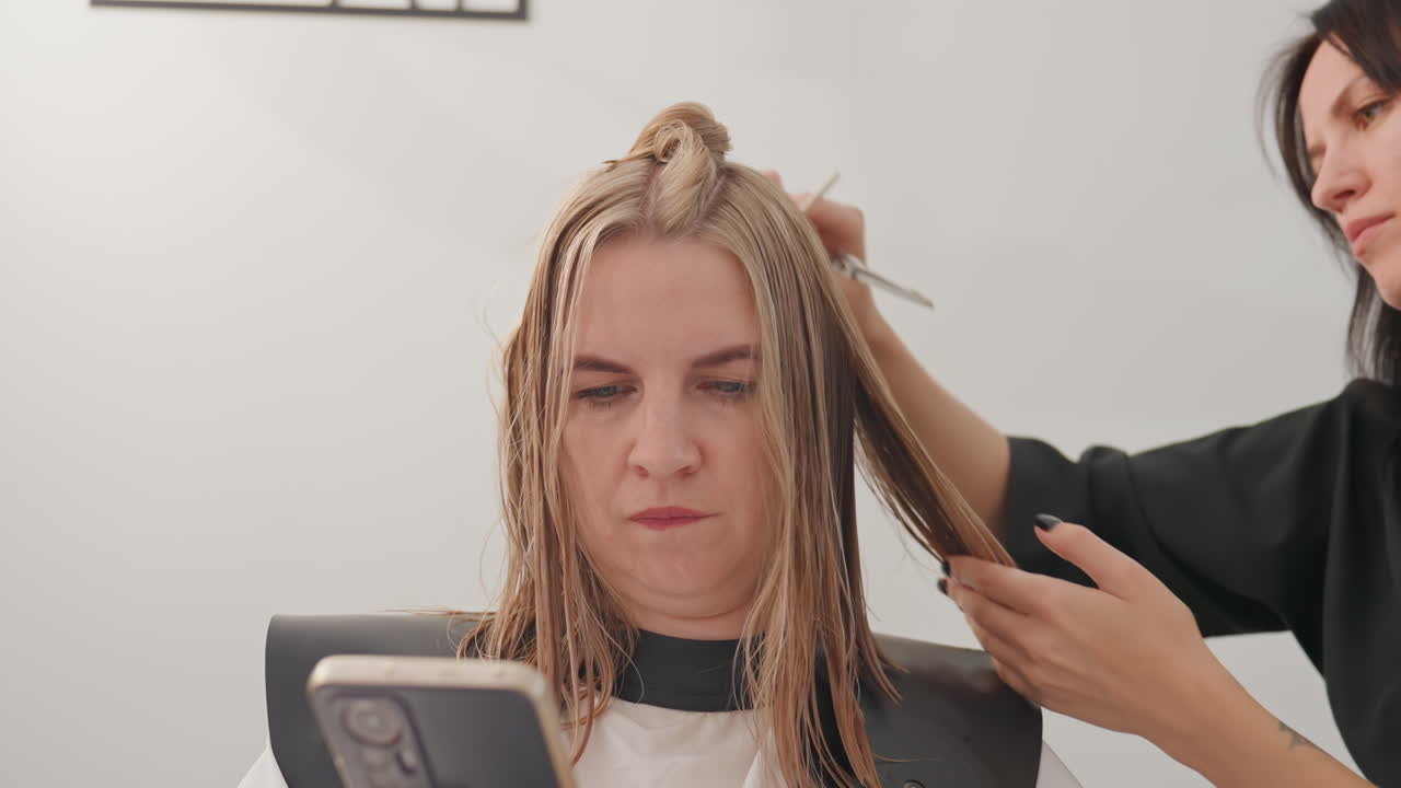 Sesión de trenzado en salón. El estilista teje cuidadosamente unas trenzas de raíz precisas. Primer plano del cuero cabelludo con un elaborado trabajo de trenzado. El cliente recibe microtrenzas hechas por expertos en un entorno de estudio profesional