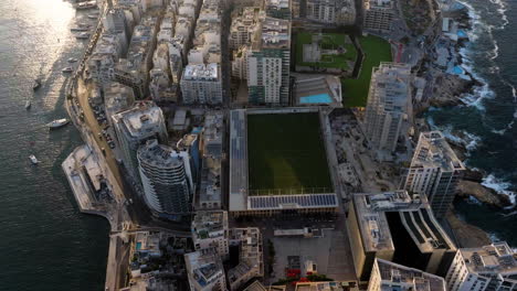 Aerial-view-tilting-over-the-Tigne-Point,-sunny-evening-in-Sliema,-Malta