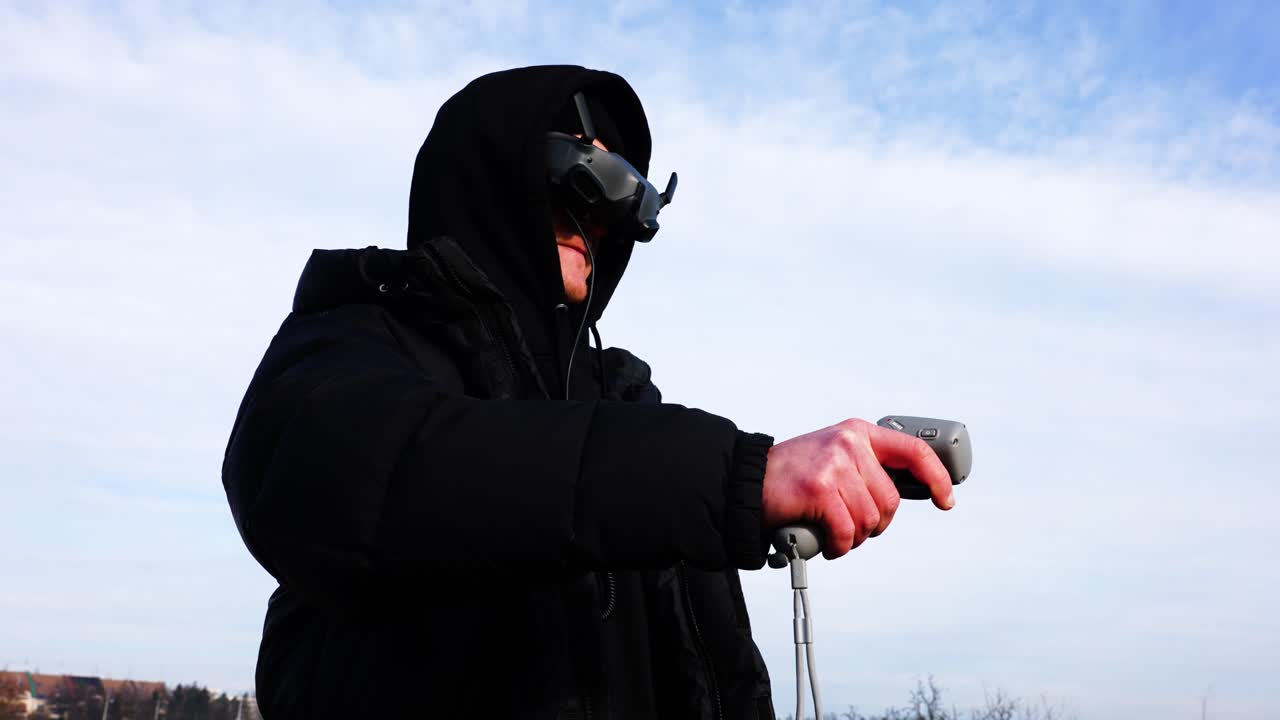 남자는 fpv 드론 안경을 착용하고 라디오 제어 리모컨으로 항공기를 기동합니다.