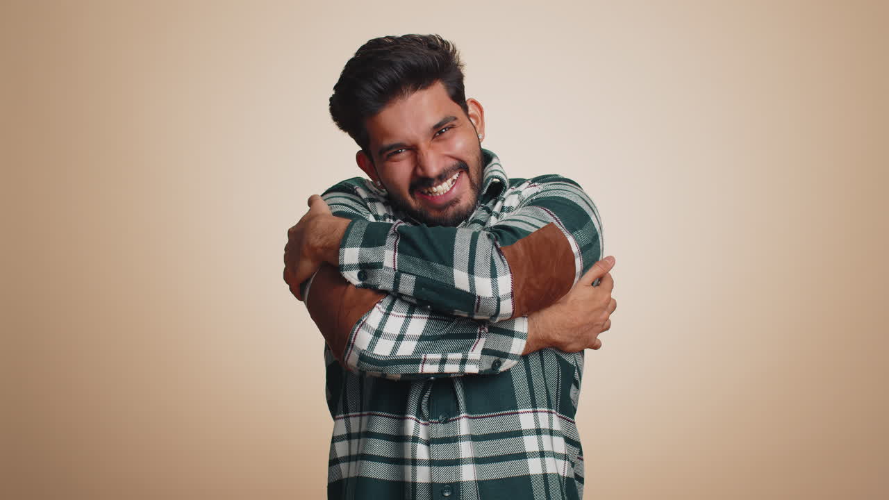 Homem indiano barbudo abrindo os braços para te abraçar, com expressão agradável, transmitindo amor e felicidade.