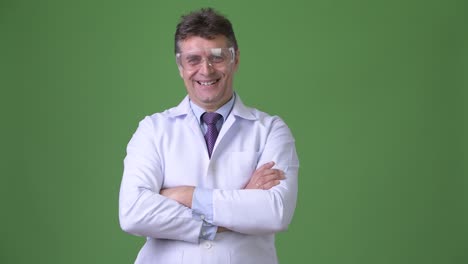 hombre maduro y guapo médico contra fondo verde