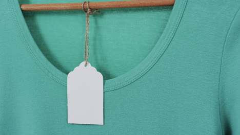 video van groen t-shirt met tag en kopieerruimte op witte achtergrond