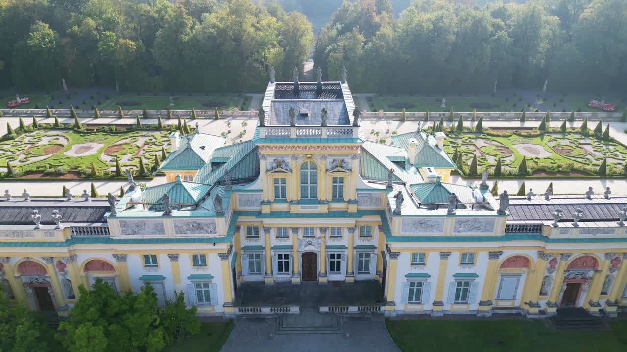 Drone aerial footage of Wilanów Palace in Warsaw with baroque architecture, decorative facade, gardens and scenic morning sunlight highlighting historic royal landmark