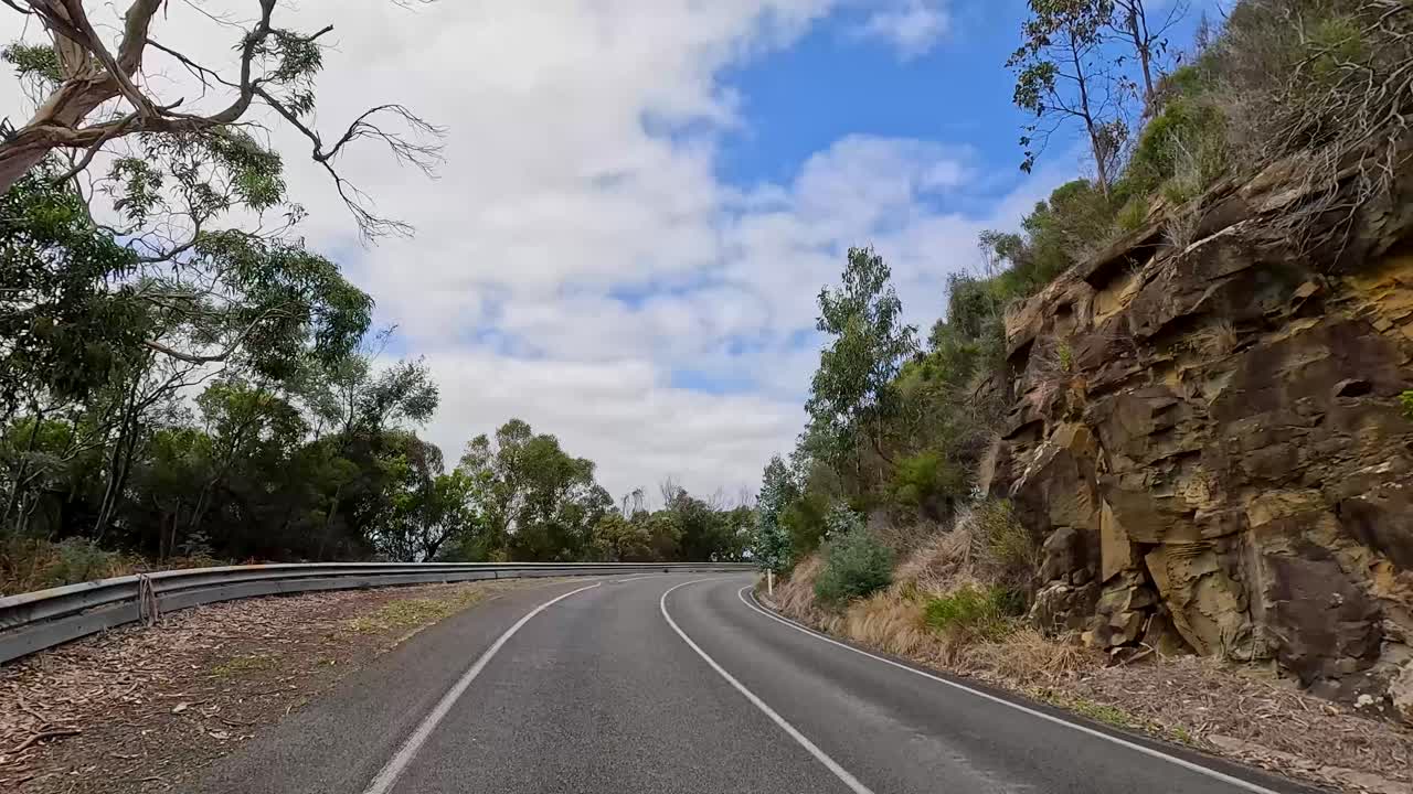 A 13-second video captures a serene drive along the winding Great Ocean Road, surrounded by lush greenery and coastal views