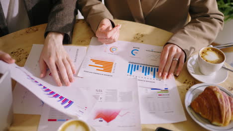 two business partners meet at a cafe to analyze business data and discuss strategy