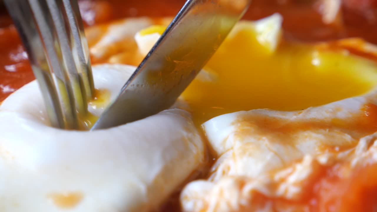 토마토 소스와 함께 포시 된 계란을 잘라