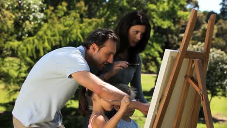 parents and children painting a canvas