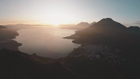 Heller-Goldener-Sonnenaufgang-über-Der-Silhouette-Der-Berge-In-Der-Nähe-Des-Atitlan-Sees,-Luftbild