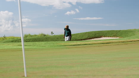 Distant-view-of-african-american-man-practicing-golf-on-the-golf-course.