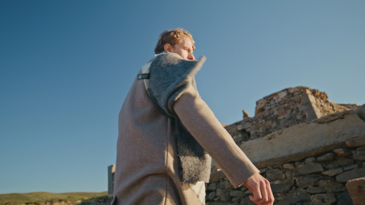 Angry man walking castle ruins place closeup. Nervous young man throwing stone