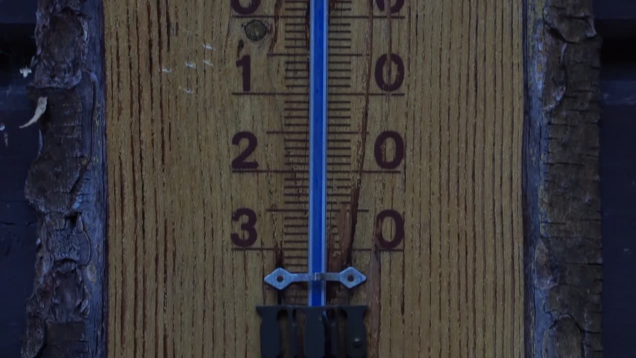 termómetro celcius de madera con escala azul y dibujo de ciervo en la parte superior en clima frío