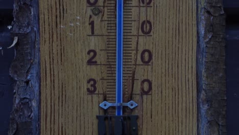 Hölzernes-Celsius-thermometer-Mit-Blauer-Skala-Und-Hirschzeichnung-Auf-Der-Oberseite-Bei-Kaltem-Wetter