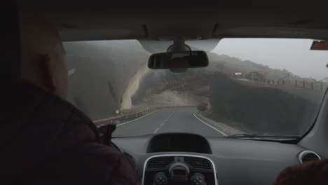 una vista en cámara lenta desde un parabrisas de un coche moviéndose más allá de la roca volcánica