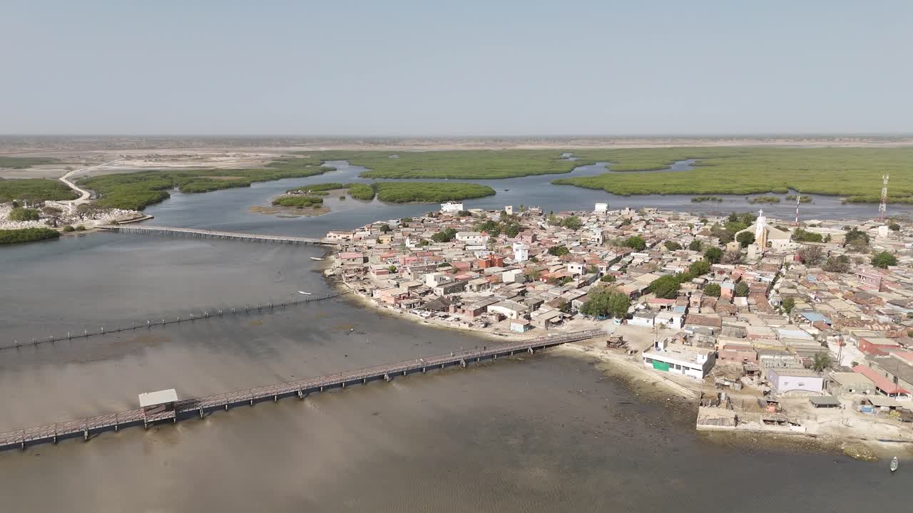 Aerial drone wide angle view of Joal Fadiouth lagoon in Senegal, showing shell island, coastal houses and water channels in a scenic traditional African landscape