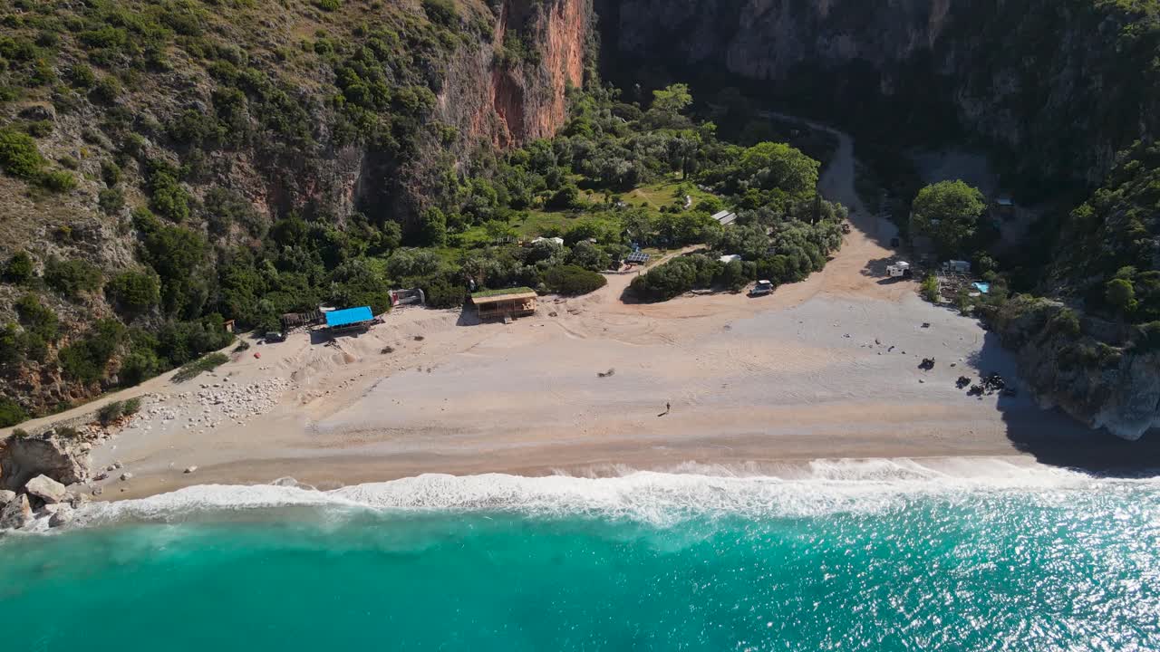 One man at the secluded Gjipe Beach surrounds by mountains , Albania