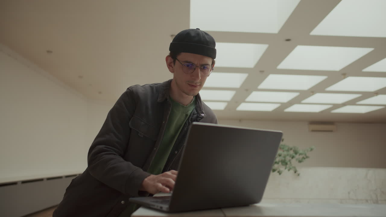 Young IT Professional Working on Laptop in Modern Office