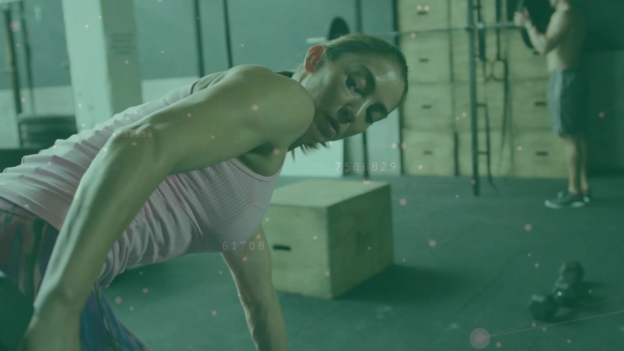 Woman doing one-arm row in gym, gripping hex dumbbell activating rep counter for strength training