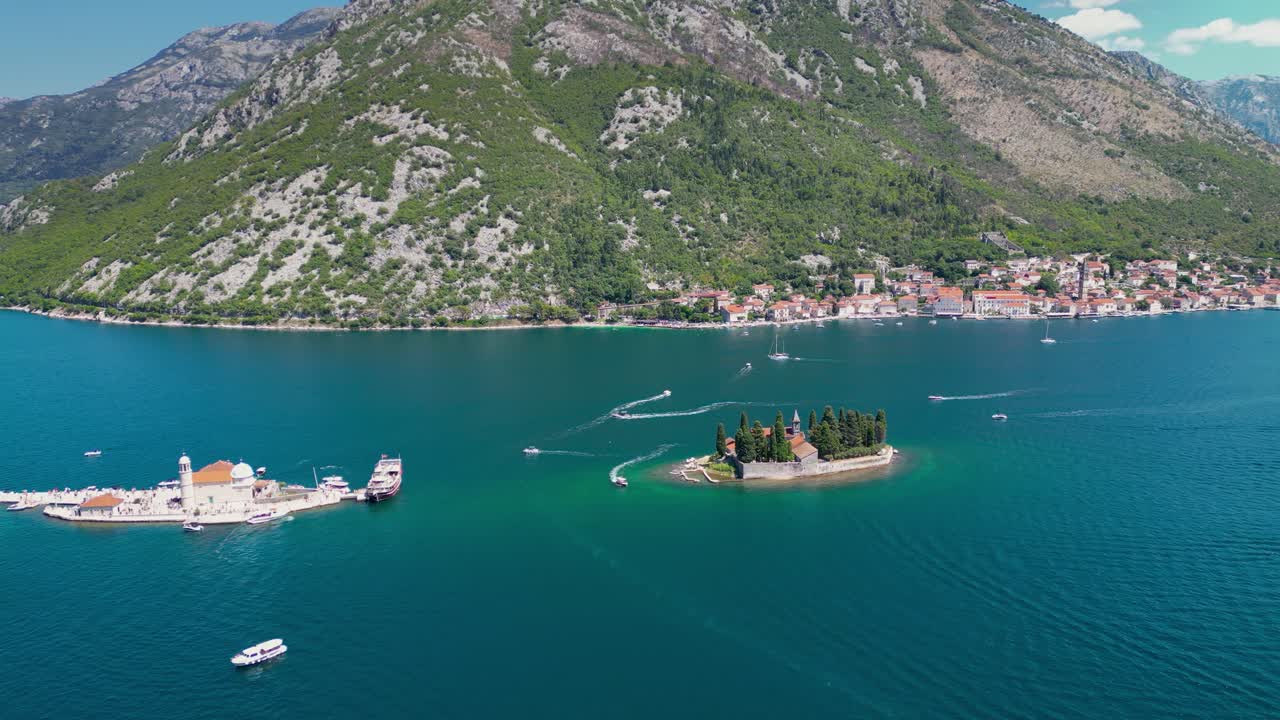 Sveti Dorde Island, Montenegro, aerial view. Church of Our Lady of Škrpjela and Saint George Monastery. Perast City in Background. Drone track right. Famous travel destination.