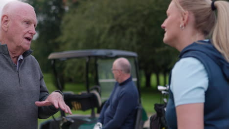 a man and a woman talking on a golf course