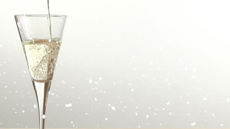 Animation-of-snow-falling-over-champagne-glass-on-white-background