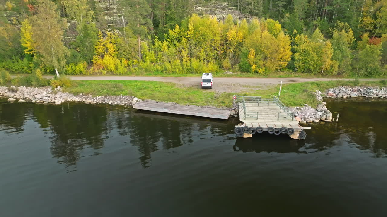 스웨덴 에서 가을 에 거울 반사 를 가진 호수 연안 에 주차 된 캠퍼반