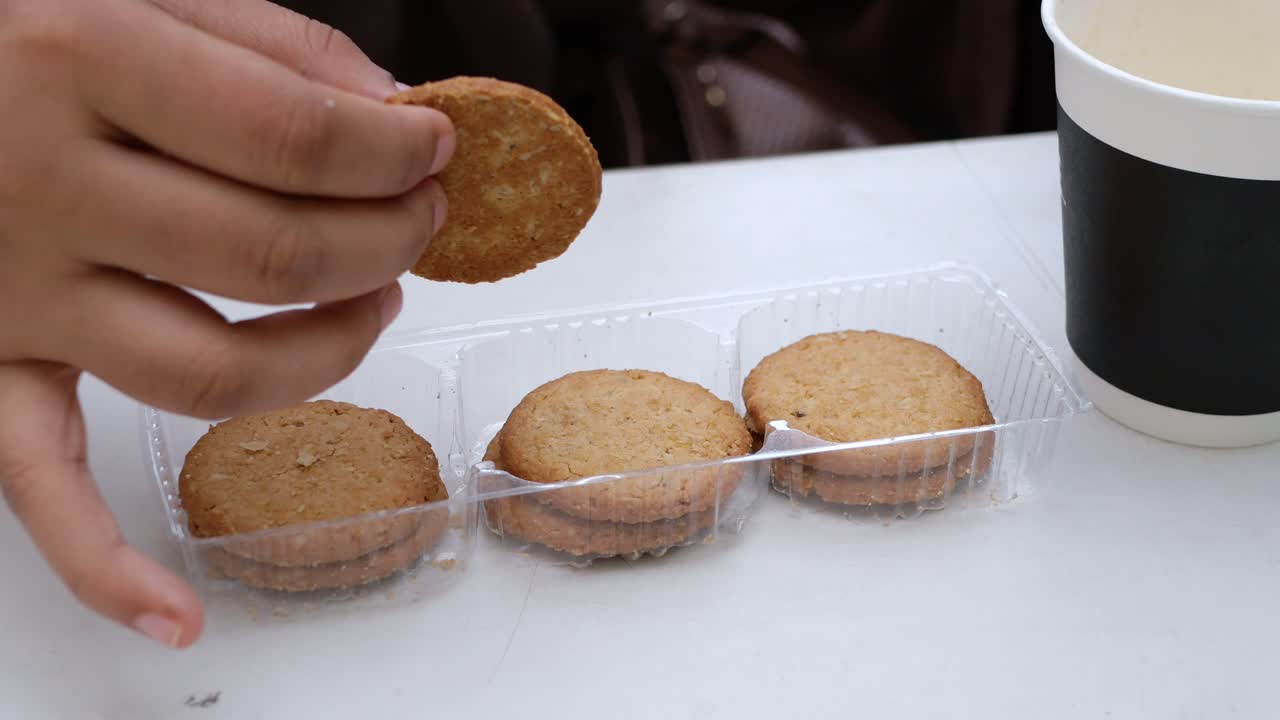 Hand pick cookies and tea on table ,