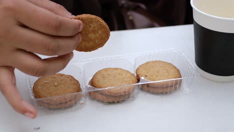 Hand-pick-cookies-and-tea-on-table-,