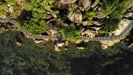 Top-view-of-a-wooden-deck-pathway-by-the-rocks