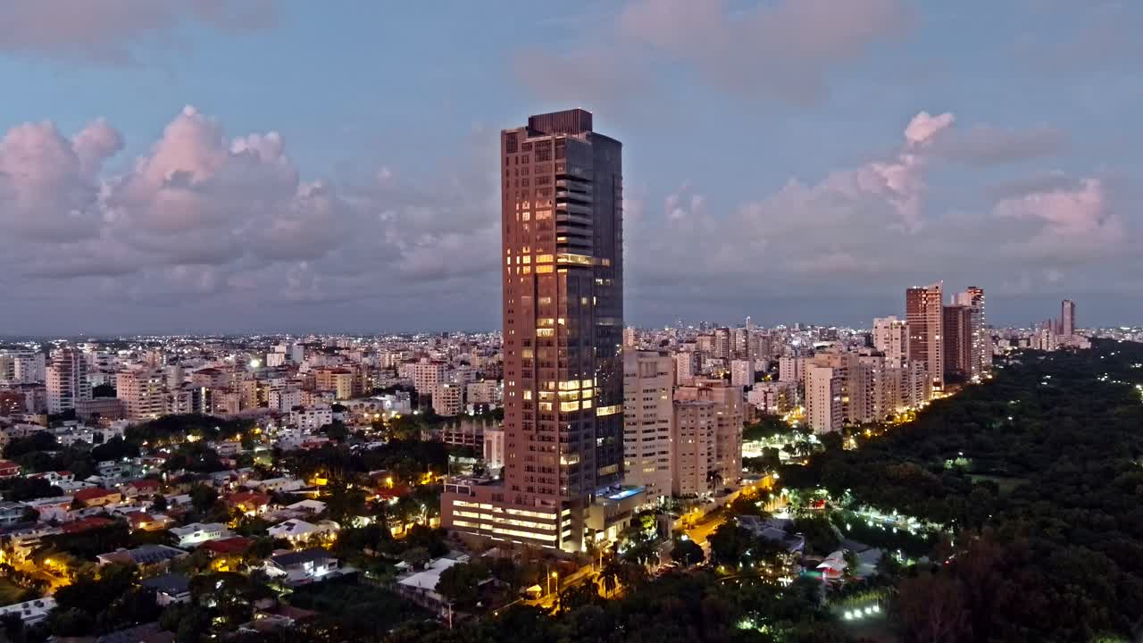 Aerial view in front of the Anacaona 27 skyscraper, sunset in Mirador Del Sur, Santo Domingo, Dominican Republic - descending, drone shot