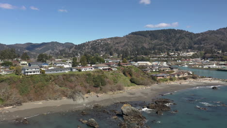 panorama de estructuras cerca de la costa con montañas boscosas en el fondo cerca del puerto de brookings en oregon